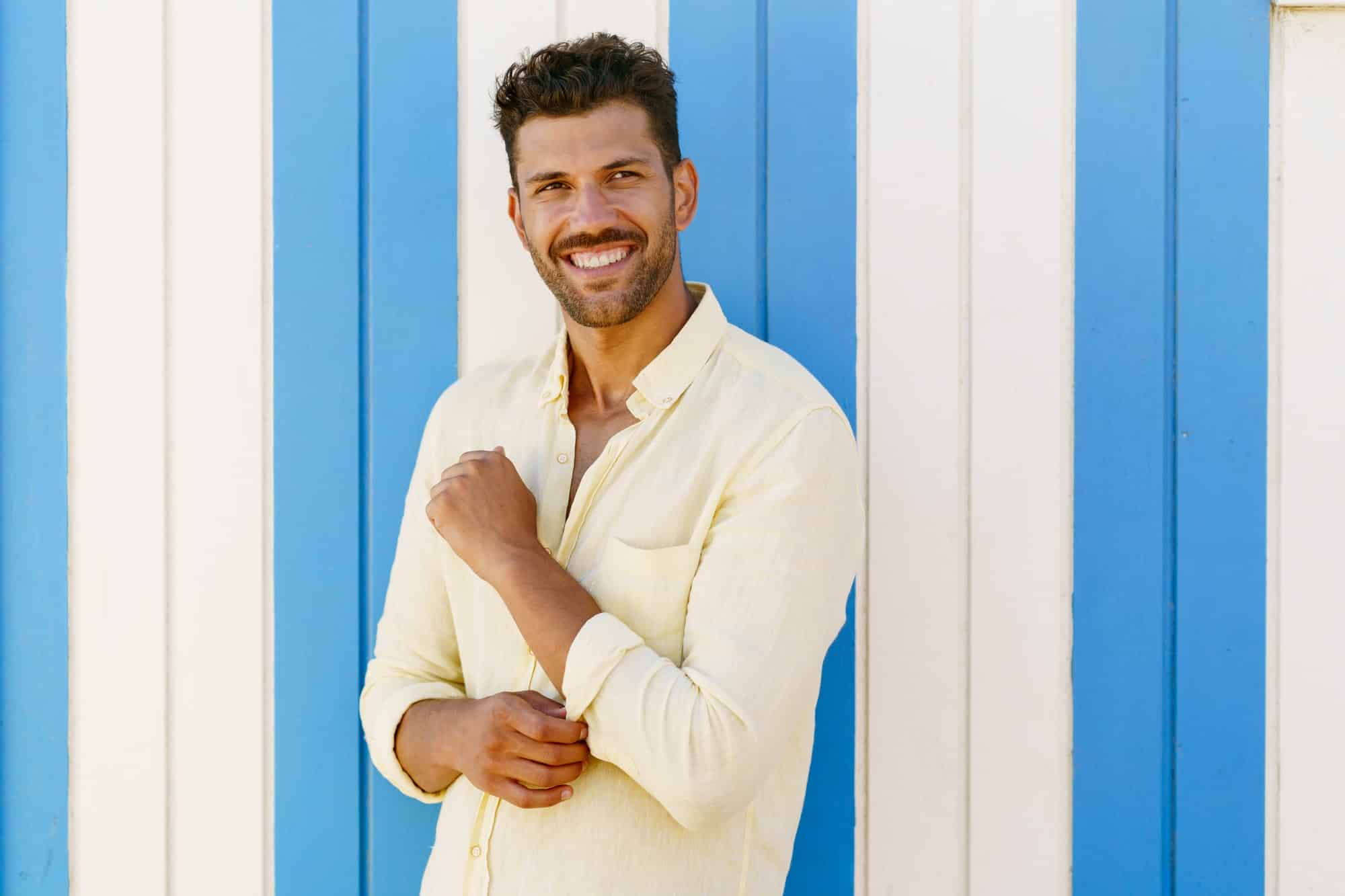 Young man, fashion model, posing in front of a beach booth
